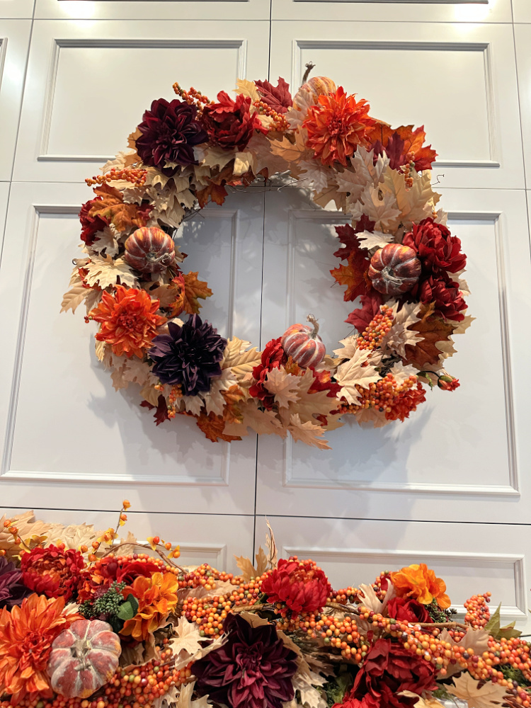 Fall wreath with faux pumpkins.