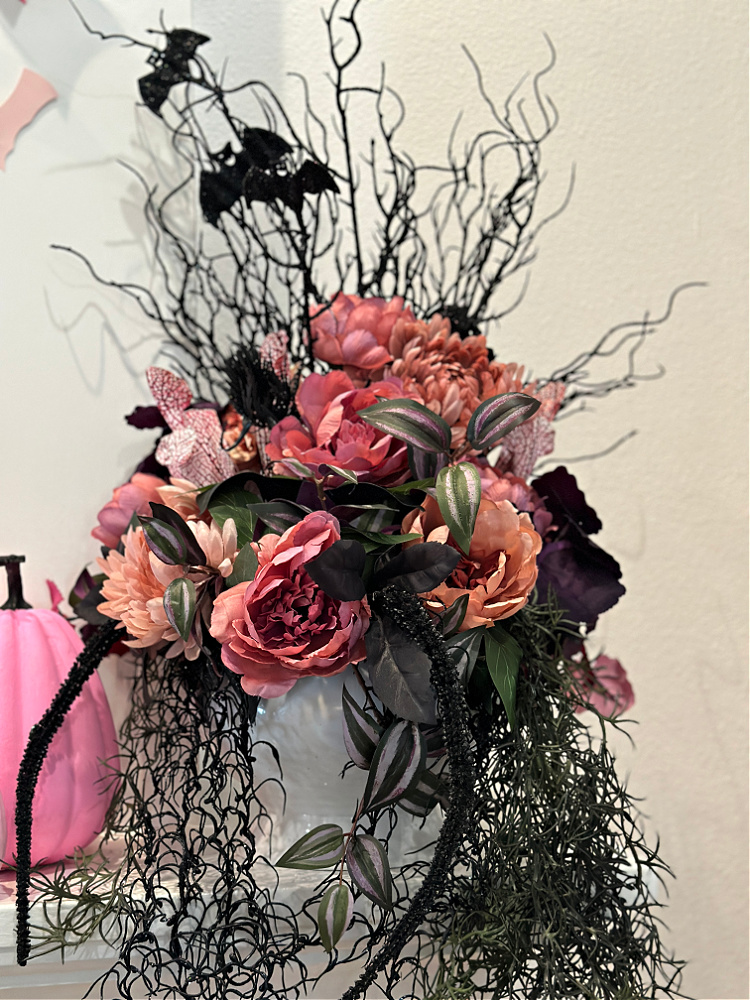 Spooky pink and shades of pink and mauve in a floral arrangement with black leaves. 
