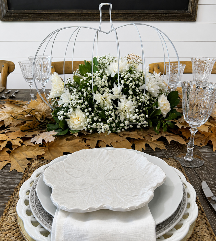 Elegant DIY Dollar Tree pumpkin floral centerpiece created from wire pumpkin wreath frames and filled with fresh white flowers,