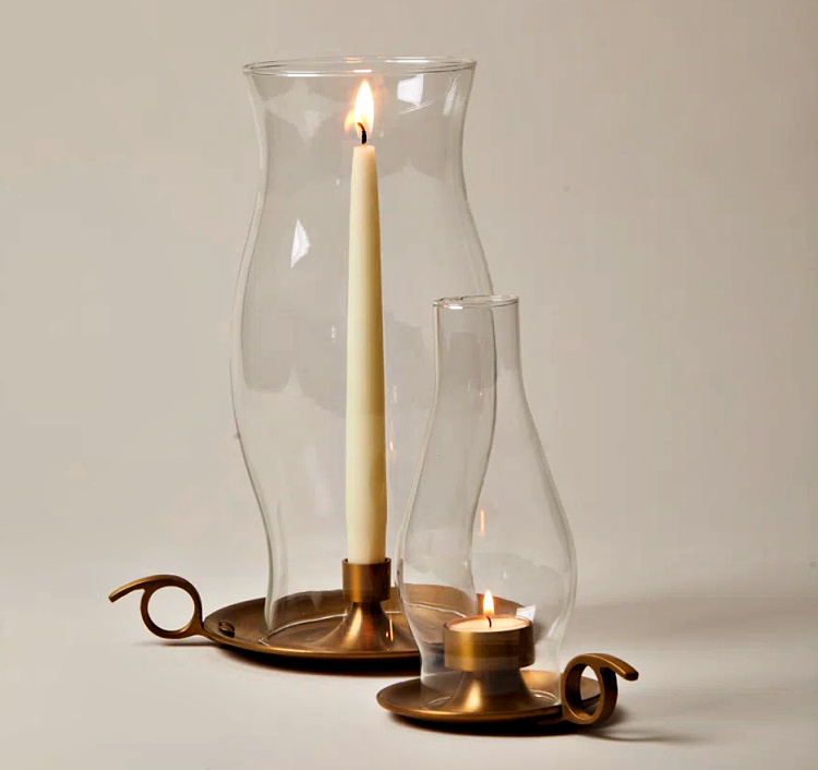 Brass lanterns with glowing pillar candles styled on a marble-topped console, creating a warm and inviting atmosphere for late summer decorating.