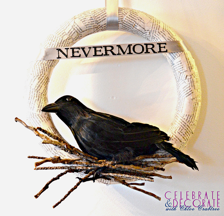 Book-page Halloween wreath featuring a black raven perched on a bundle of twigs beneath a “Nevermore” banner.